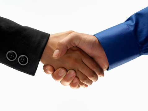 Businessman and businesswoman shaking hands, close-up